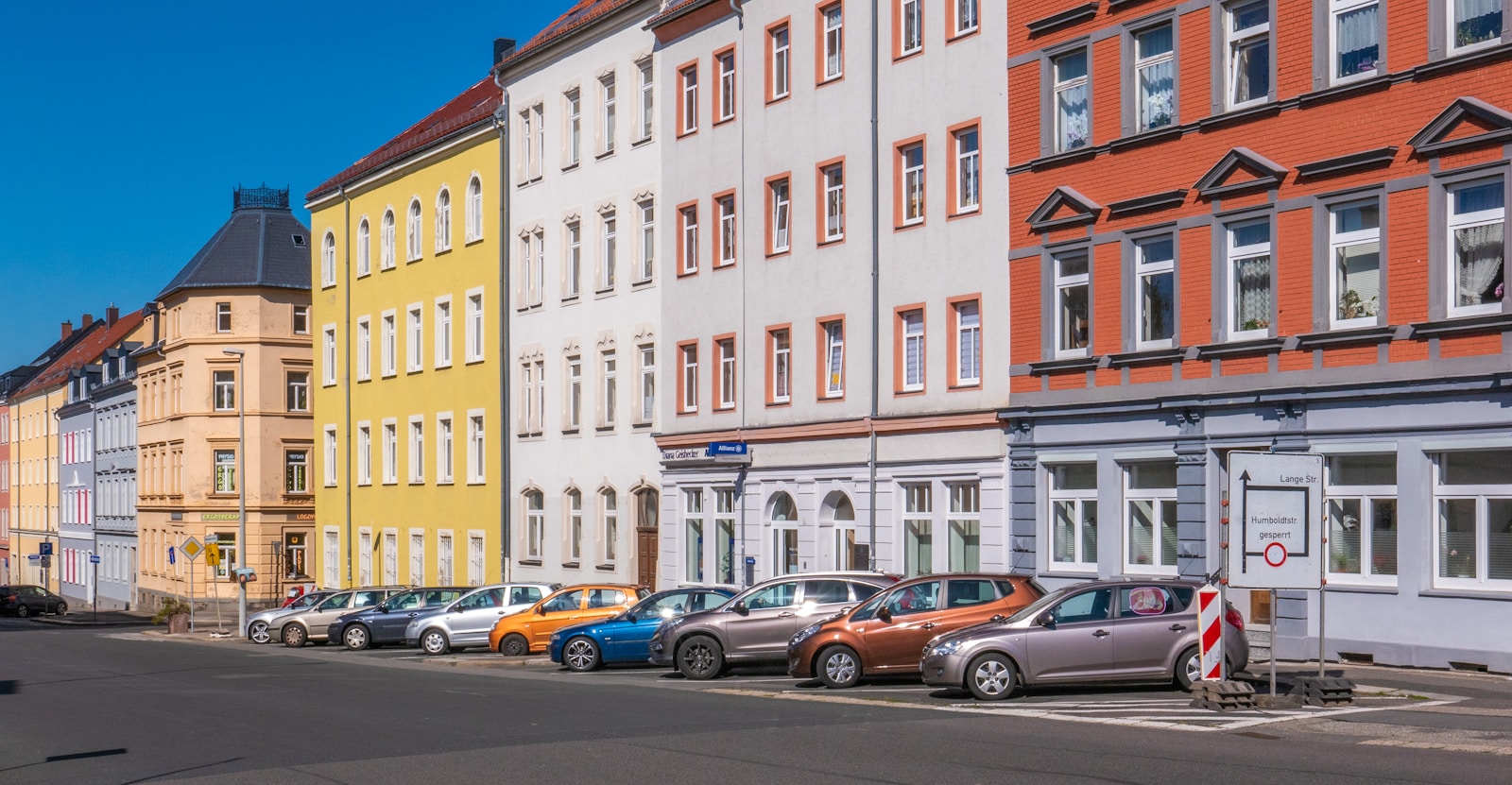 assorted-color cars parked beside apartments, renters